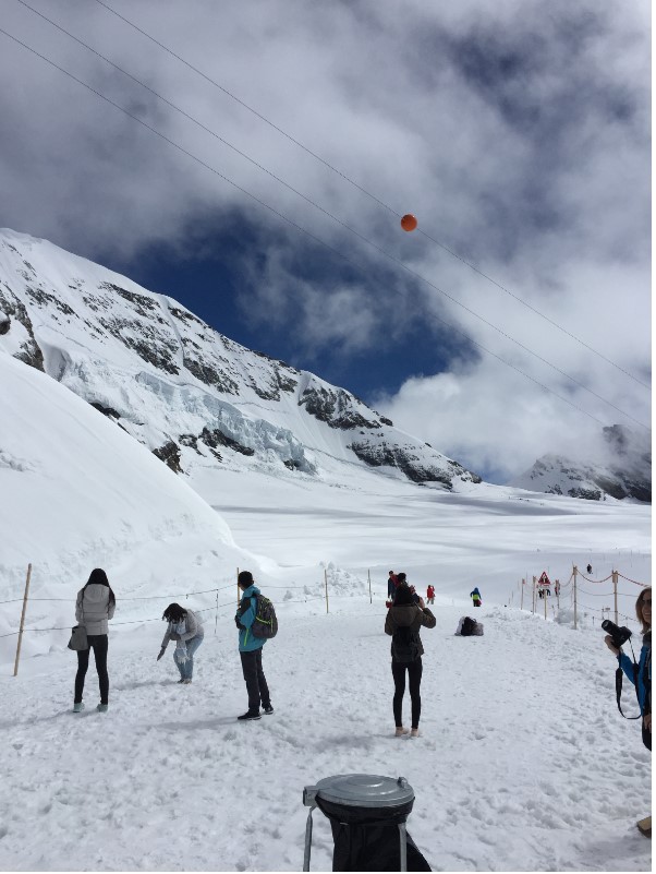 A group of people standing on top of a snow covered slope

Description automatically generated